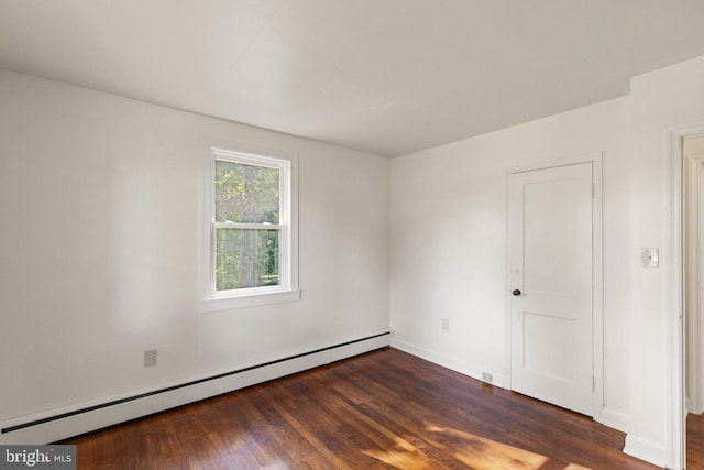 empty room featuring baseboard heating and wood finished floors