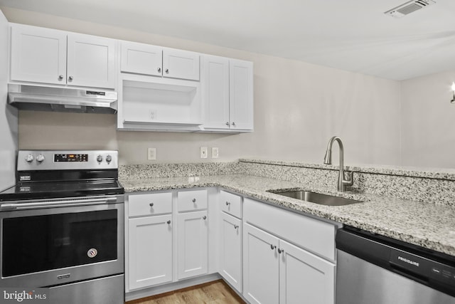 kitchen with under cabinet range hood, stainless steel appliances, a sink, visible vents, and white cabinets