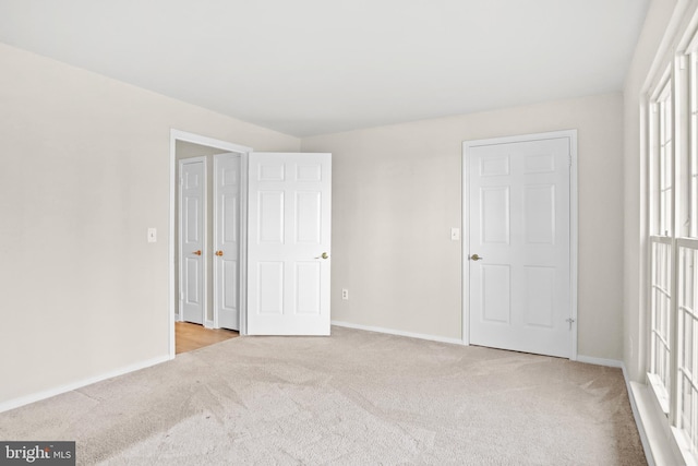 unfurnished bedroom with carpet and baseboards