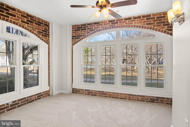 unfurnished sunroom with a ceiling fan