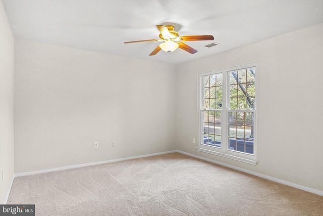 carpeted empty room with visible vents, baseboards, and ceiling fan