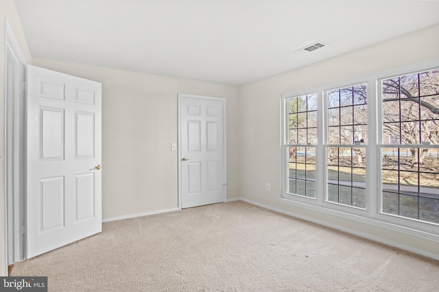 unfurnished bedroom featuring carpet flooring, visible vents, and baseboards