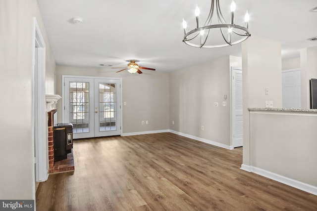 unfurnished living room with french doors, baseboards, and wood finished floors