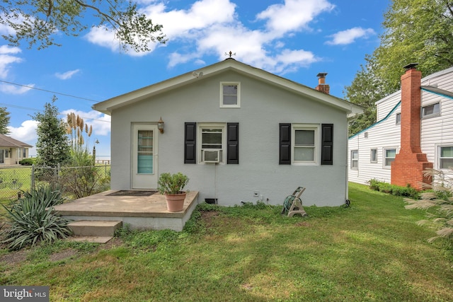 back of property featuring a patio, a lawn, fence, and stucco siding