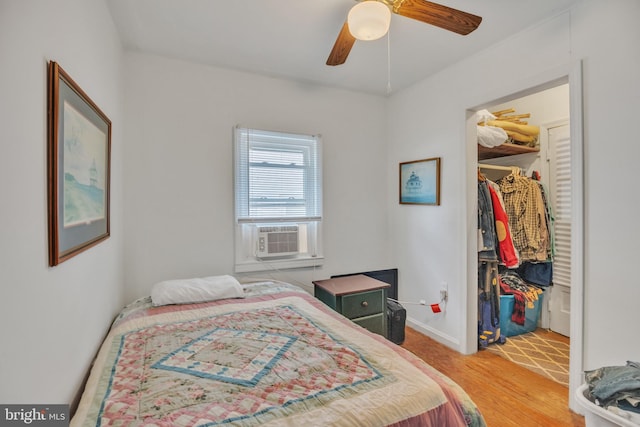 bedroom featuring ceiling fan, a spacious closet, cooling unit, light wood-style floors, and a closet