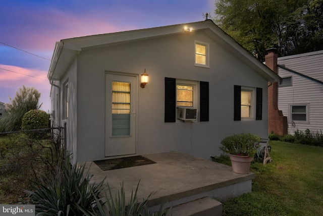 view of front of property featuring a yard, a patio, fence, and stucco siding