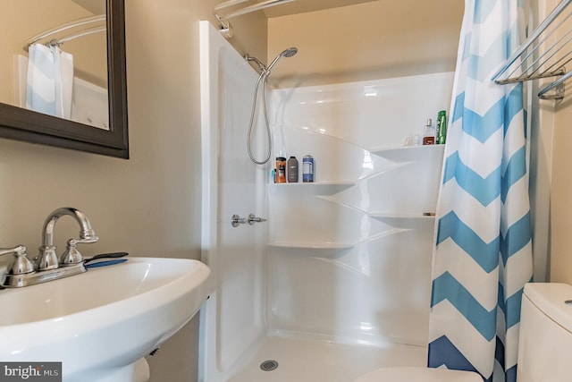 full bathroom with a shower with curtain, a sink, and toilet