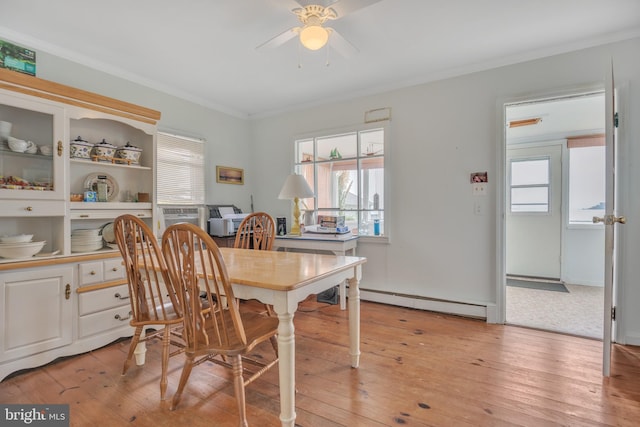 dining room with light wood-type flooring, a baseboard radiator, crown molding, and ceiling fan