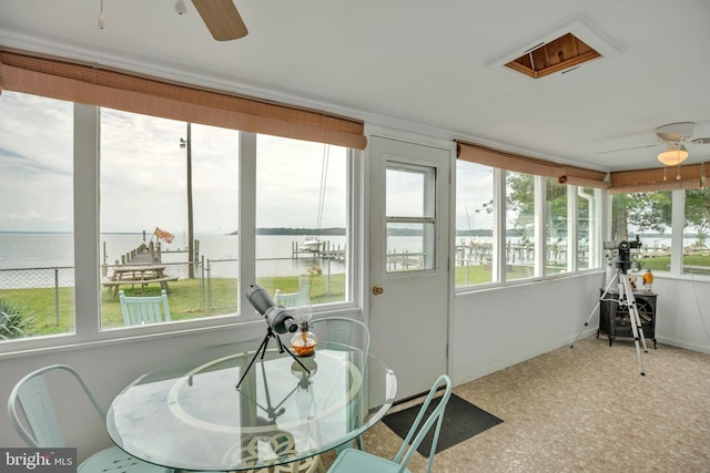 sunroom / solarium featuring a water view