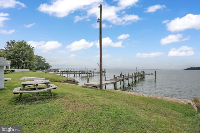 view of dock with a water view and a yard