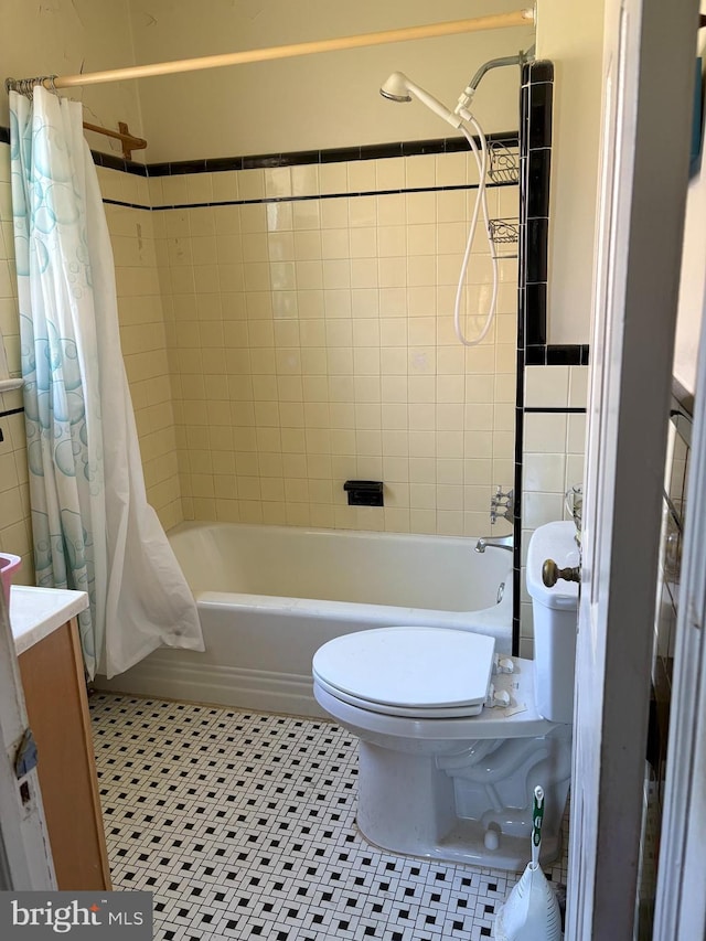 full bath with shower / bath combo, toilet, vanity, and tile patterned flooring