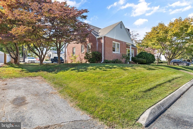 view of side of home with a yard and brick siding