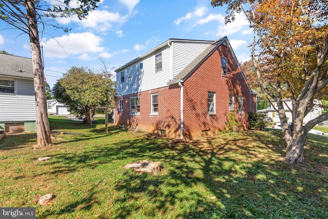 view of side of home featuring a garage, a lawn, and brick siding