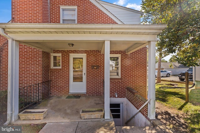 doorway to property featuring brick siding