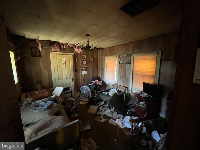 miscellaneous room with a chandelier and wood walls