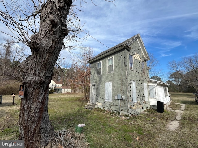 view of property exterior featuring entry steps and a lawn