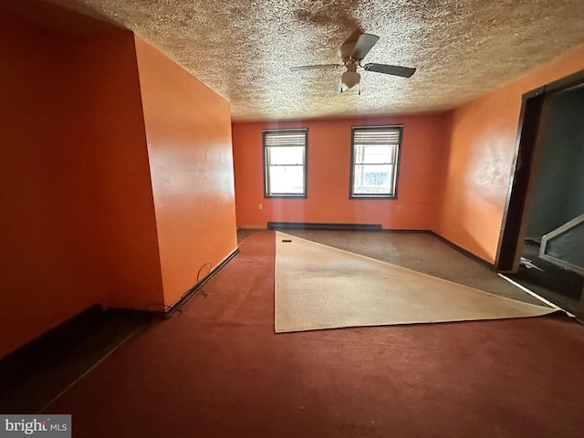 unfurnished room with ceiling fan, baseboards, and a textured ceiling