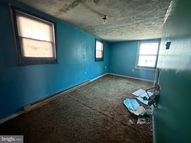 carpeted spare room featuring a textured ceiling, baseboard heating, and baseboards