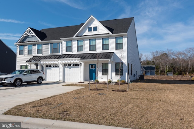 view of front of home featuring metal roof, an attached garage, concrete driveway, roof with shingles, and a standing seam roof