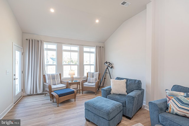 living area with recessed lighting, visible vents, baseboards, vaulted ceiling, and light wood-style floors