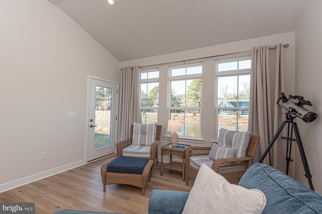 sitting room with lofted ceiling, baseboards, and wood finished floors