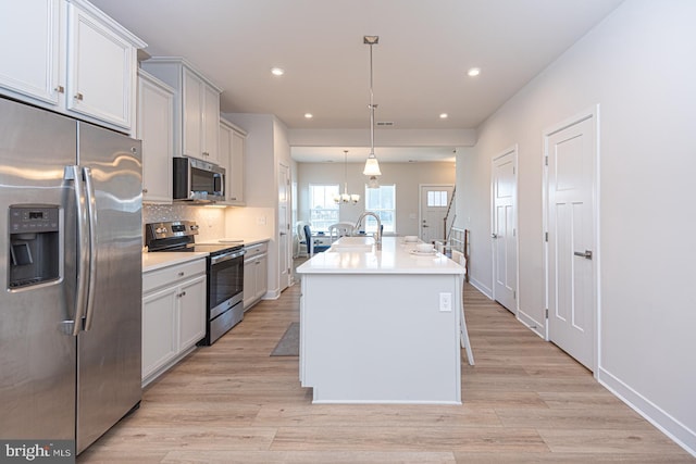 kitchen with stainless steel appliances, light countertops, light wood-style floors, and tasteful backsplash