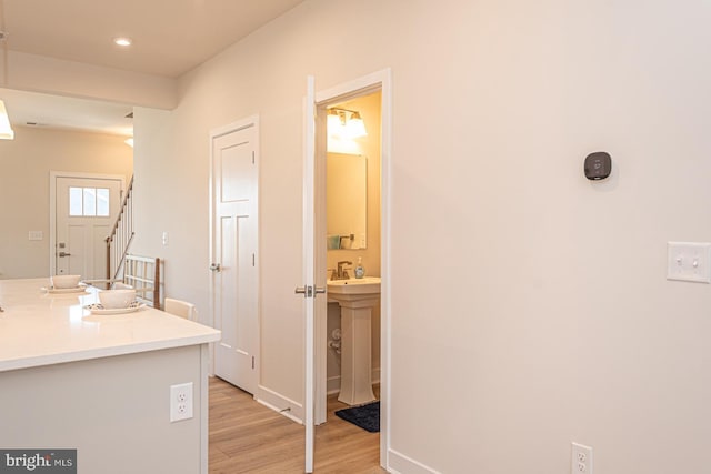 bathroom with baseboards, wood finished floors, and recessed lighting