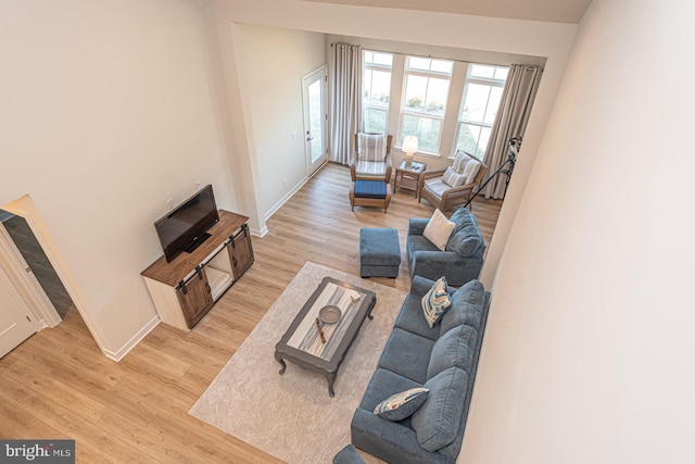 living area featuring light wood-style flooring and baseboards