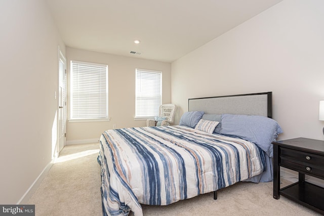 bedroom featuring baseboards, visible vents, and light colored carpet