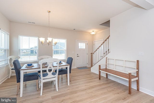 dining space featuring a wealth of natural light, light wood-type flooring, visible vents, and stairs