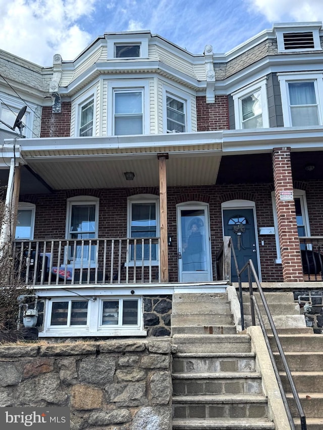 view of front of house featuring a porch and brick siding