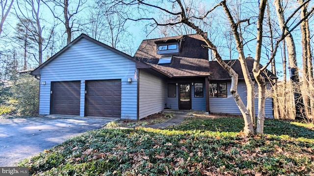 view of front of house featuring an attached garage, a shingled roof, and driveway