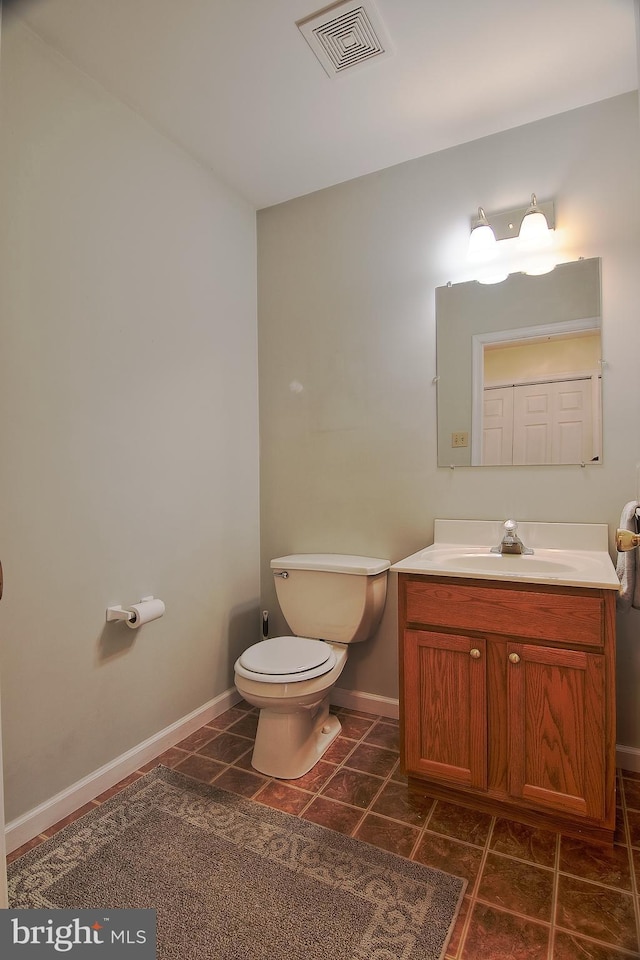 bathroom with toilet, tile patterned flooring, visible vents, and vanity