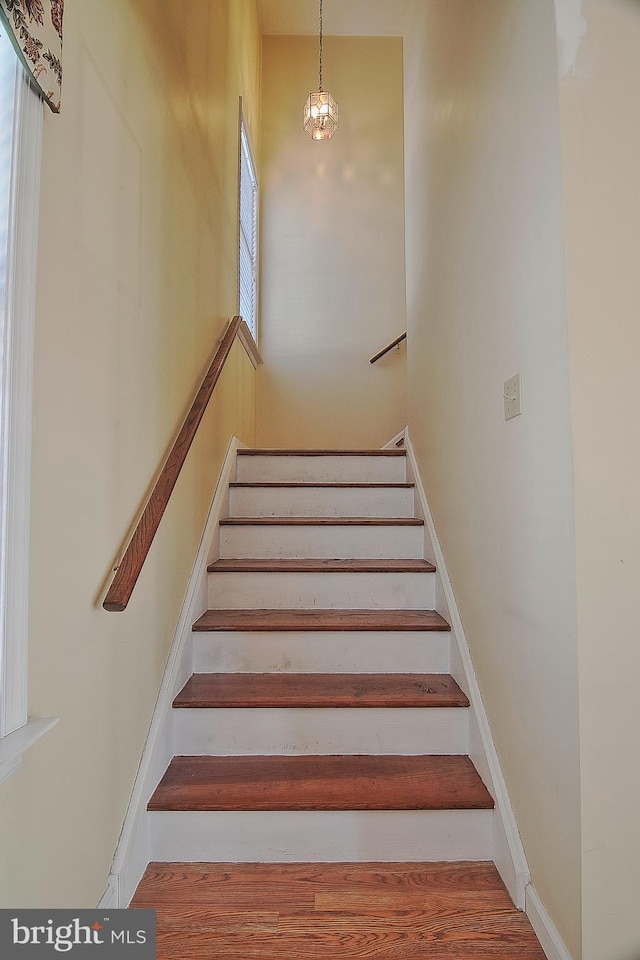 stairs with baseboards and a chandelier