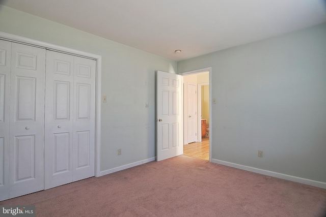 unfurnished bedroom featuring a closet, carpet flooring, and baseboards