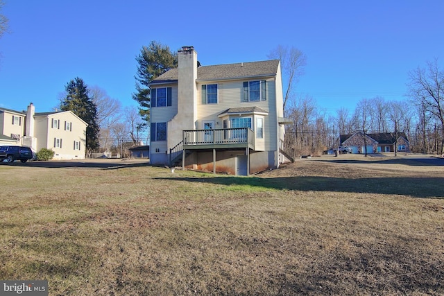 rear view of property with a deck, stairway, a yard, and a chimney