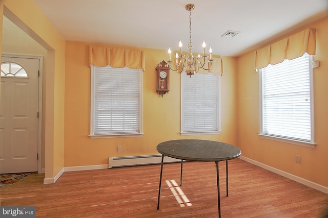 dining room featuring a chandelier, visible vents, baseboards, and wood finished floors