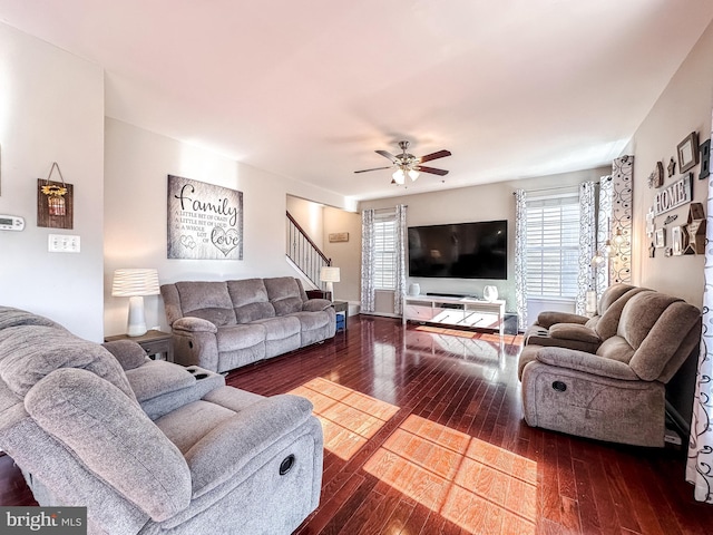 living room with stairs, dark wood-style flooring, and a ceiling fan