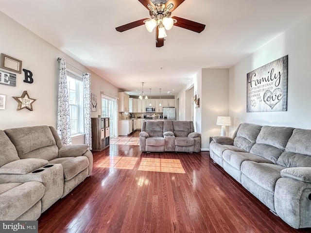 living area featuring dark wood-style flooring and a ceiling fan