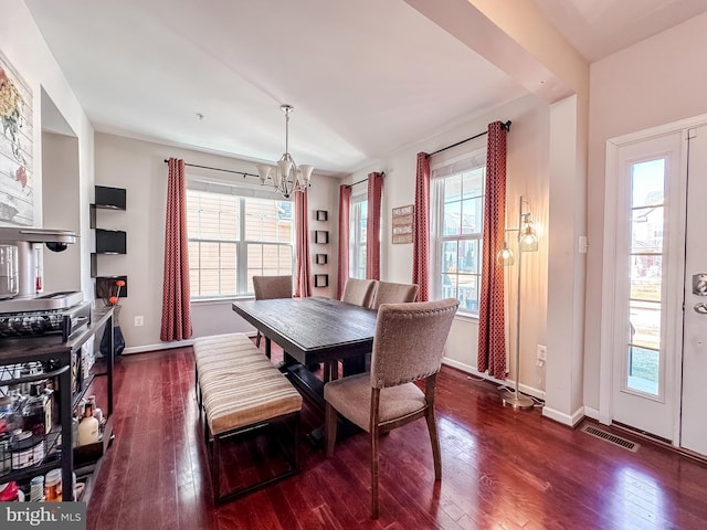 dining area with a wealth of natural light, dark wood-type flooring, visible vents, and a notable chandelier