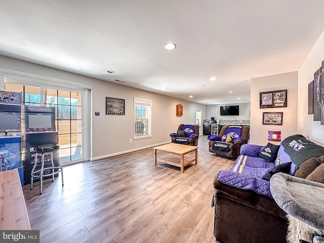 living area with baseboards, light wood finished floors, a wealth of natural light, and recessed lighting