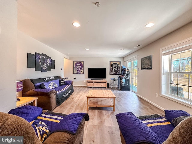 living area with light wood-type flooring, visible vents, baseboards, and recessed lighting