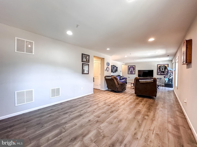 living area featuring visible vents and wood finished floors