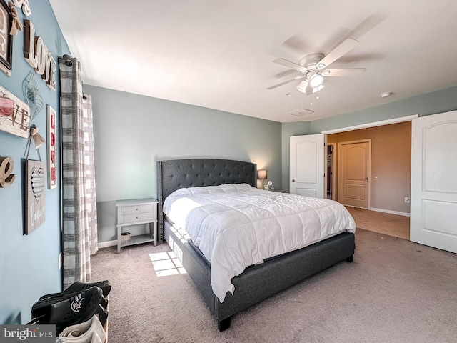 carpeted bedroom with visible vents, a ceiling fan, and baseboards