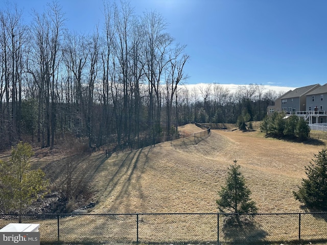 view of yard featuring fence and dirt driveway