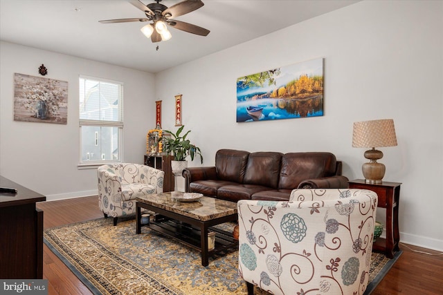 living room featuring baseboards, ceiling fan, and wood finished floors