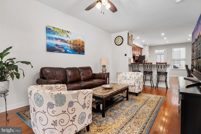 living room featuring visible vents, ceiling fan, baseboards, and hardwood / wood-style flooring