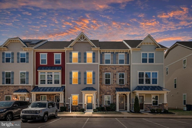 townhome / multi-family property with stone siding, metal roof, and a standing seam roof