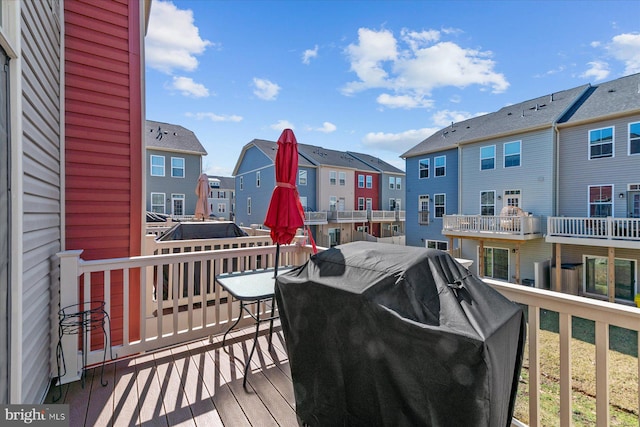 wooden deck featuring a residential view and a grill