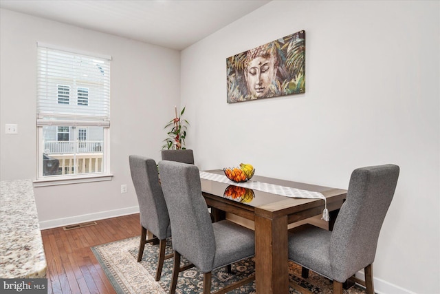 dining space featuring visible vents, baseboards, and hardwood / wood-style floors